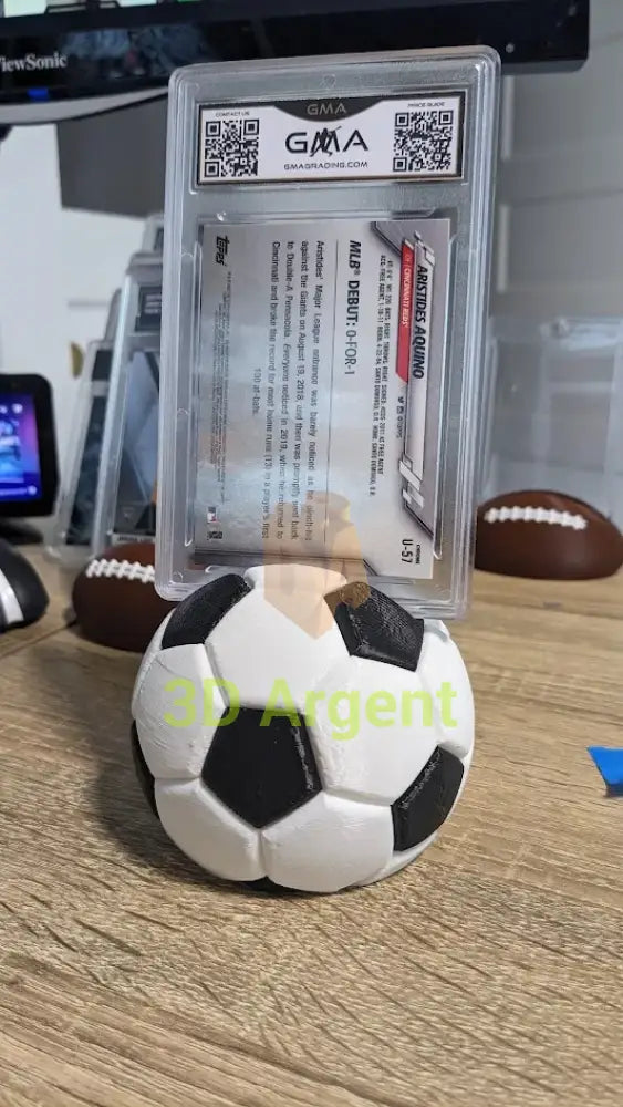 Dual-colour soccer ball display stand holding a graded sports trading card case