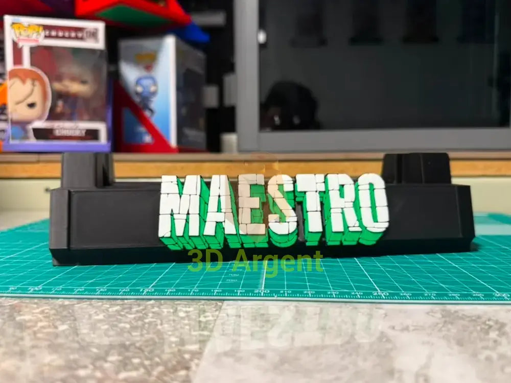 Maestro comic slab display stand, black base with white and green 3D-effect Maestro wordmark, photographed on a workbench