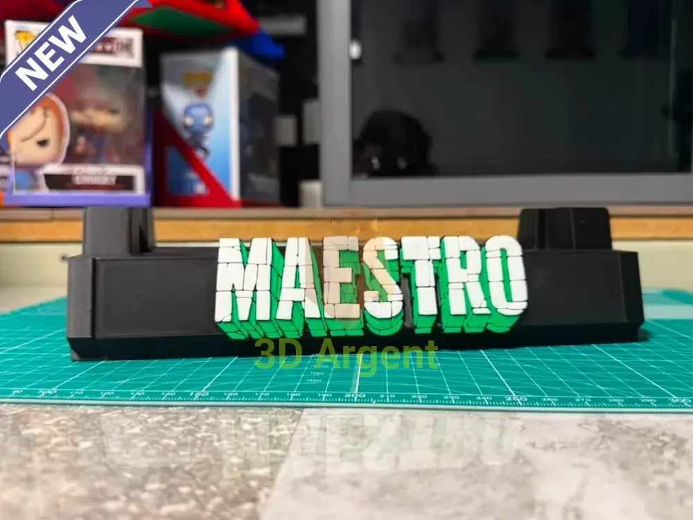 Maestro comic slab display stand, black base with white and green 3D-effect Maestro wordmark, photographed on a workbench