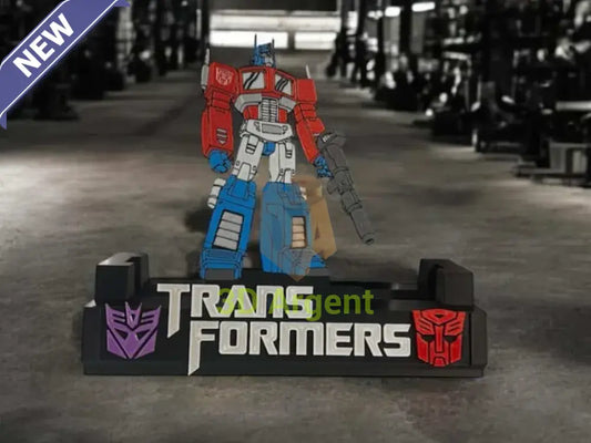 Transformers comic display stand with multi-colour Optimus Prime figure and TRANSFORMERS wordmark base