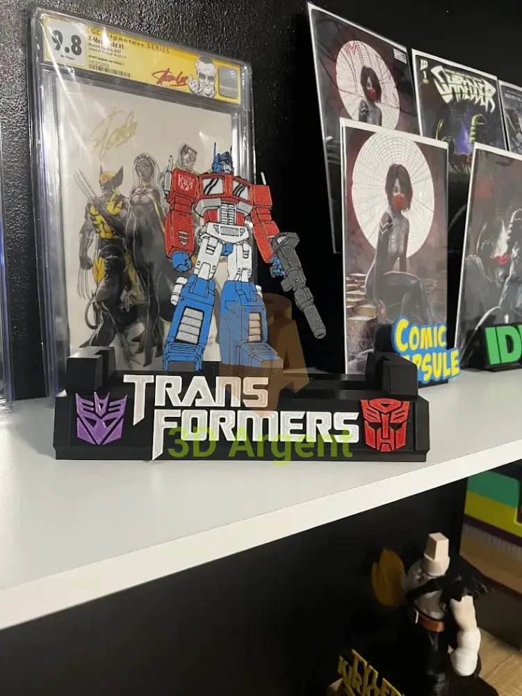 Close-up angled view of the Transformers comic display stand with multi-colour Optimus Prime figure