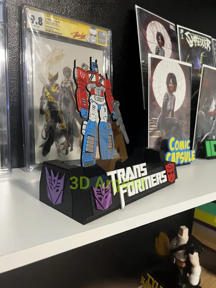 Transformers comic display stand displayed on a shelf next to a graded comic slab