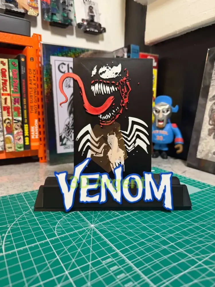 Front view of the Venom comic display stand showing the multi-colour face design and wordmark logo